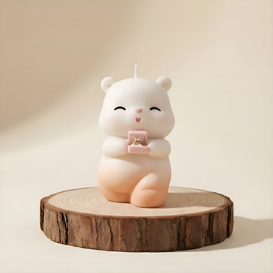 Cute bear-shaped luxury candle holding ring box on wooden base, neutral background.
