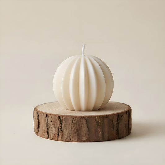 Sculpted round white luxury candle on wooden slab, minimalist background